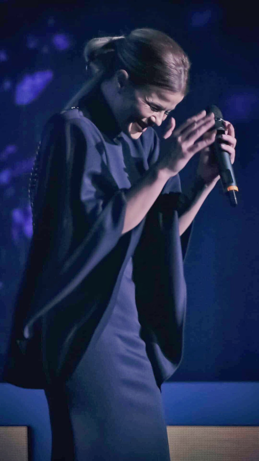 Dani Dimitrovska singing under blue stage lights